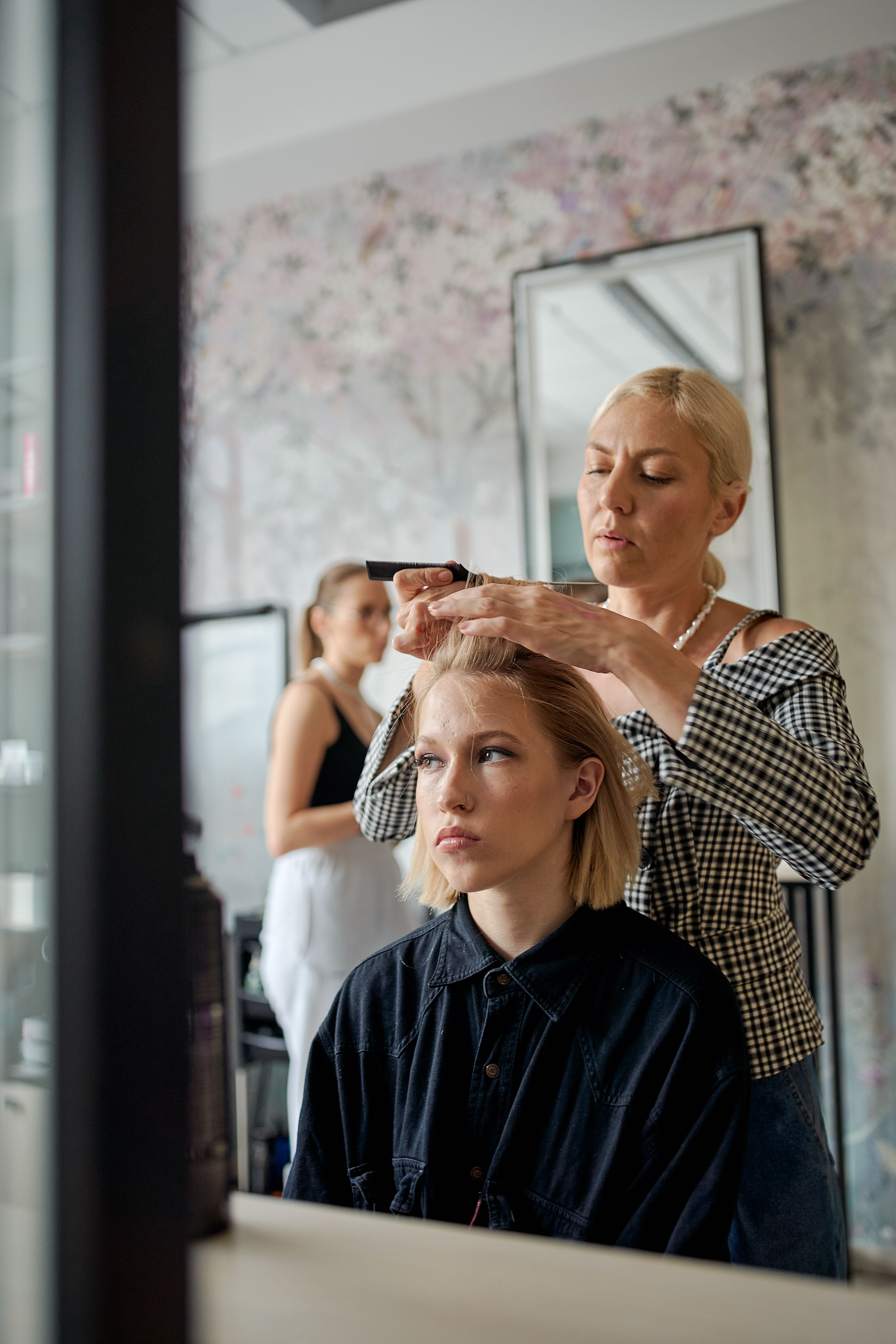 Hairdresser straightening a client's hair in a modern beauty salon